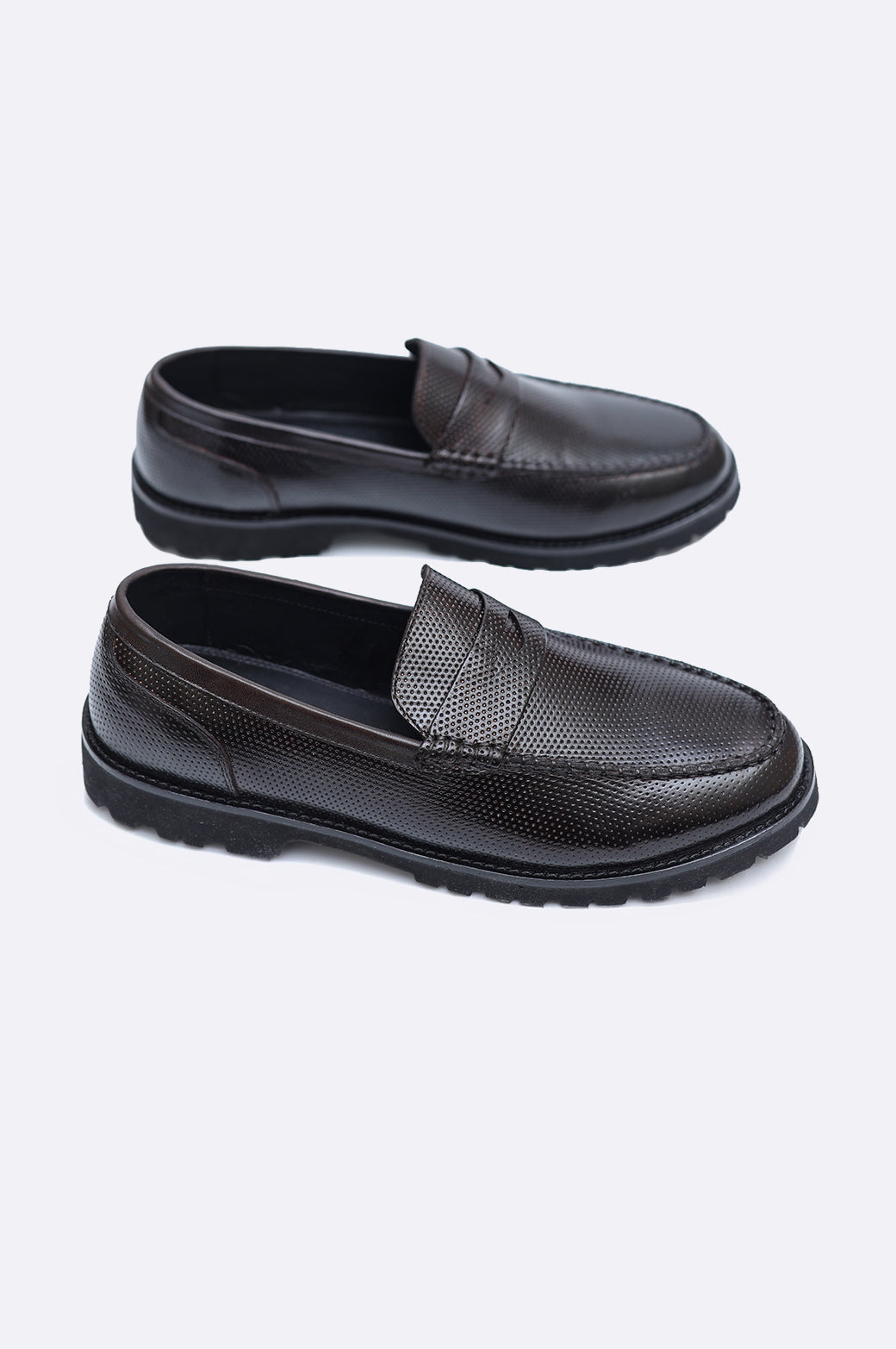 Pair of men's dark brown perforated leather penny loafers featuring a classic saddle strap and a thick black rugged lug sole.