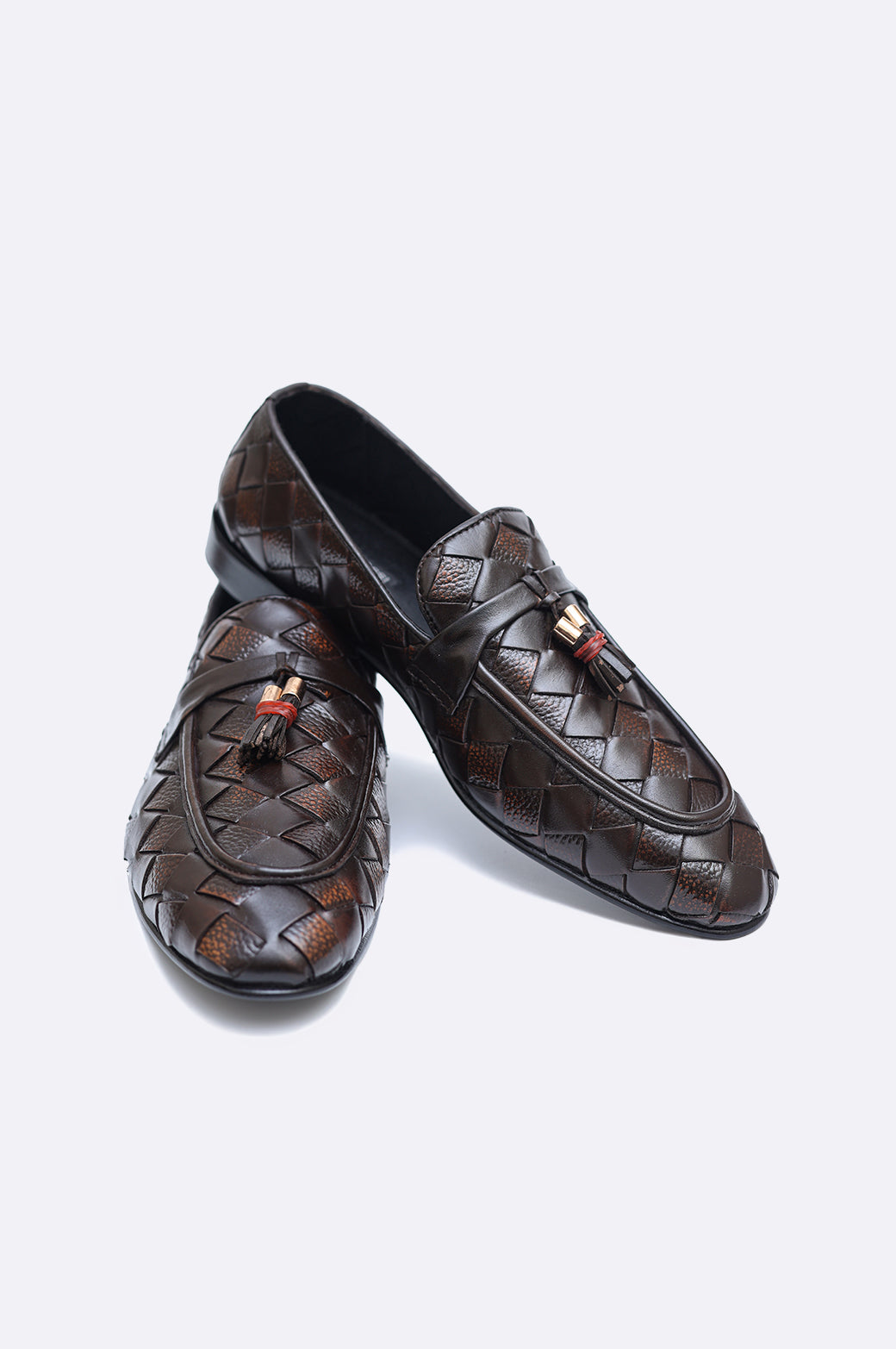 Pair of premium men's dark brown hand-woven leather loafers featuring twin tassels with gold-tone accents on a clean white background.